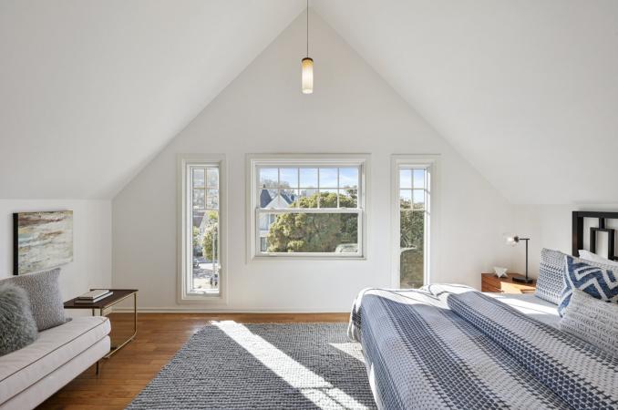 Property Thumbnail: Primary bedroom with slanted ceilings and large windows