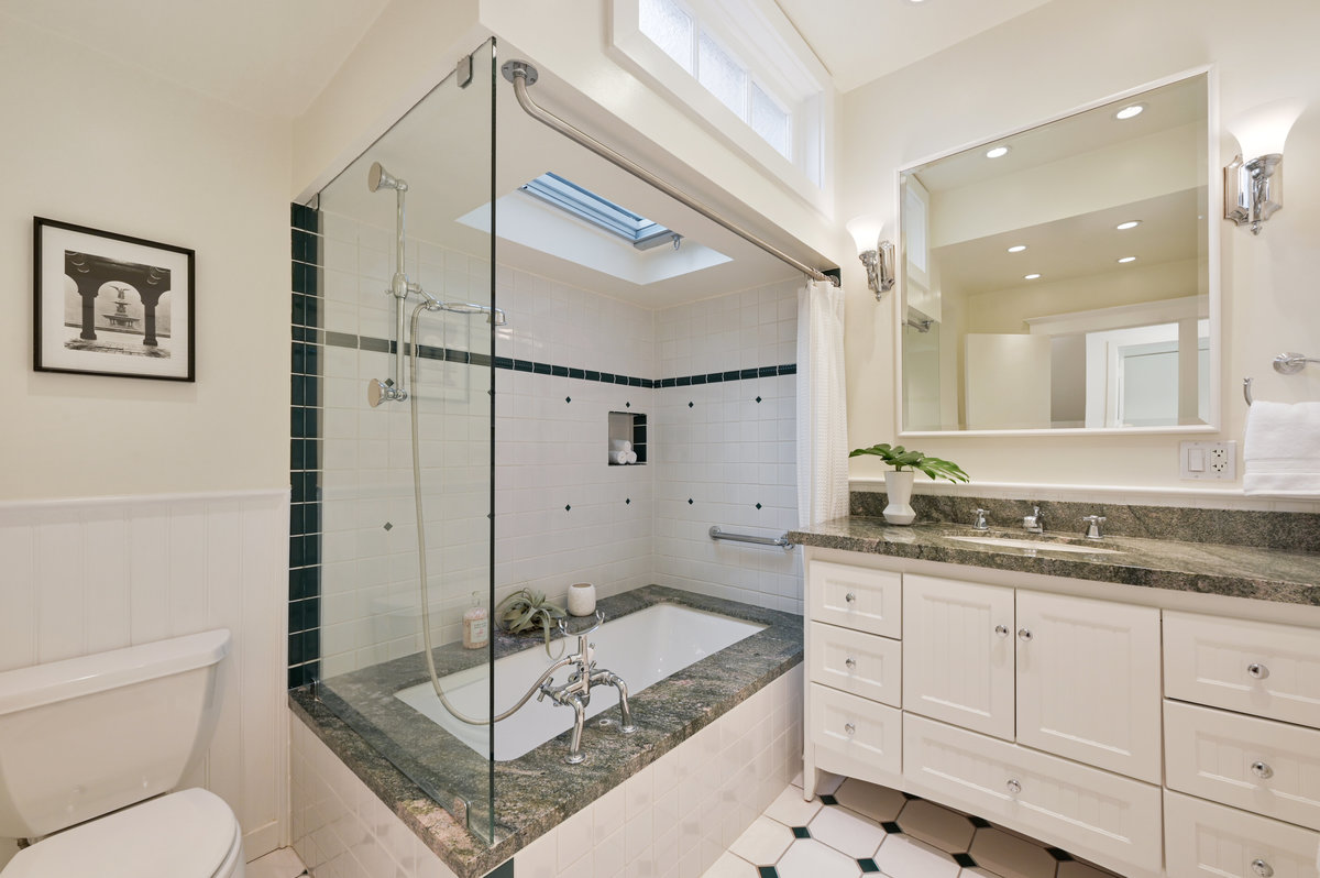 Property Photo: Bathroom two, showing a large vanity, shower and bath with a skylight above