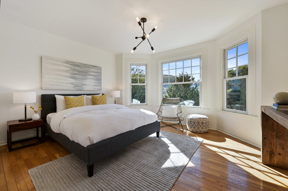 Property Photo: Bedroom two, featuring three large bay windows