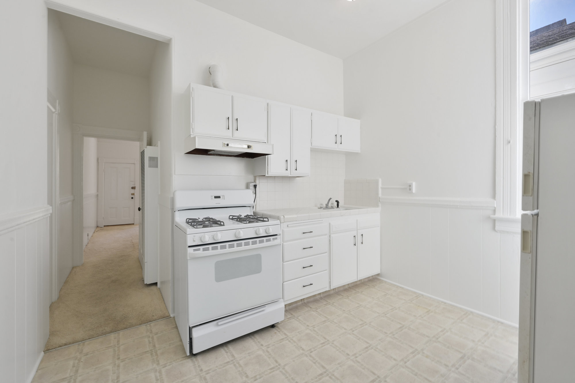 Property Photo: A kitchen with white cabinets and stove