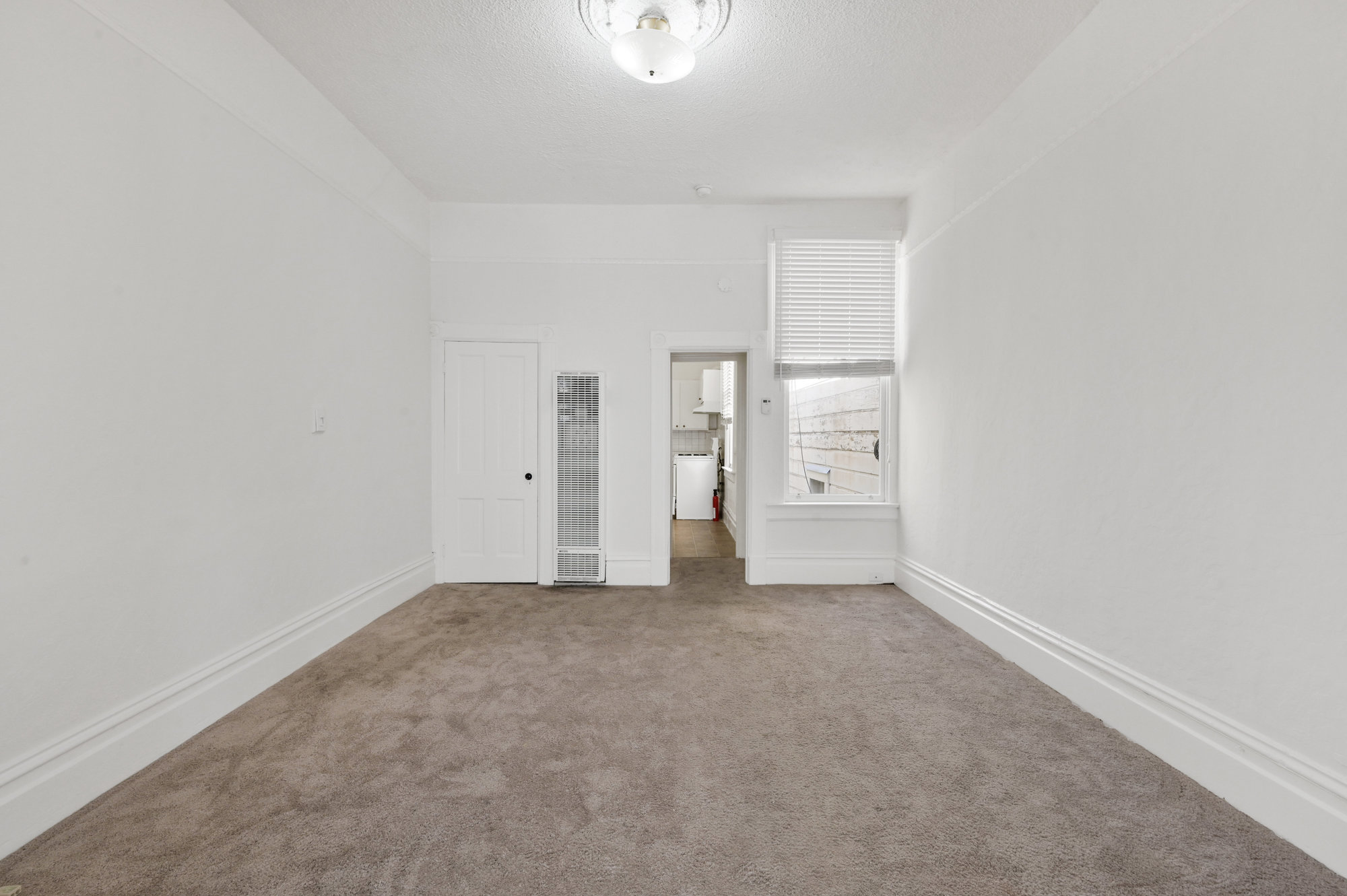 Property Photo: View of a long room with carpeting and a window