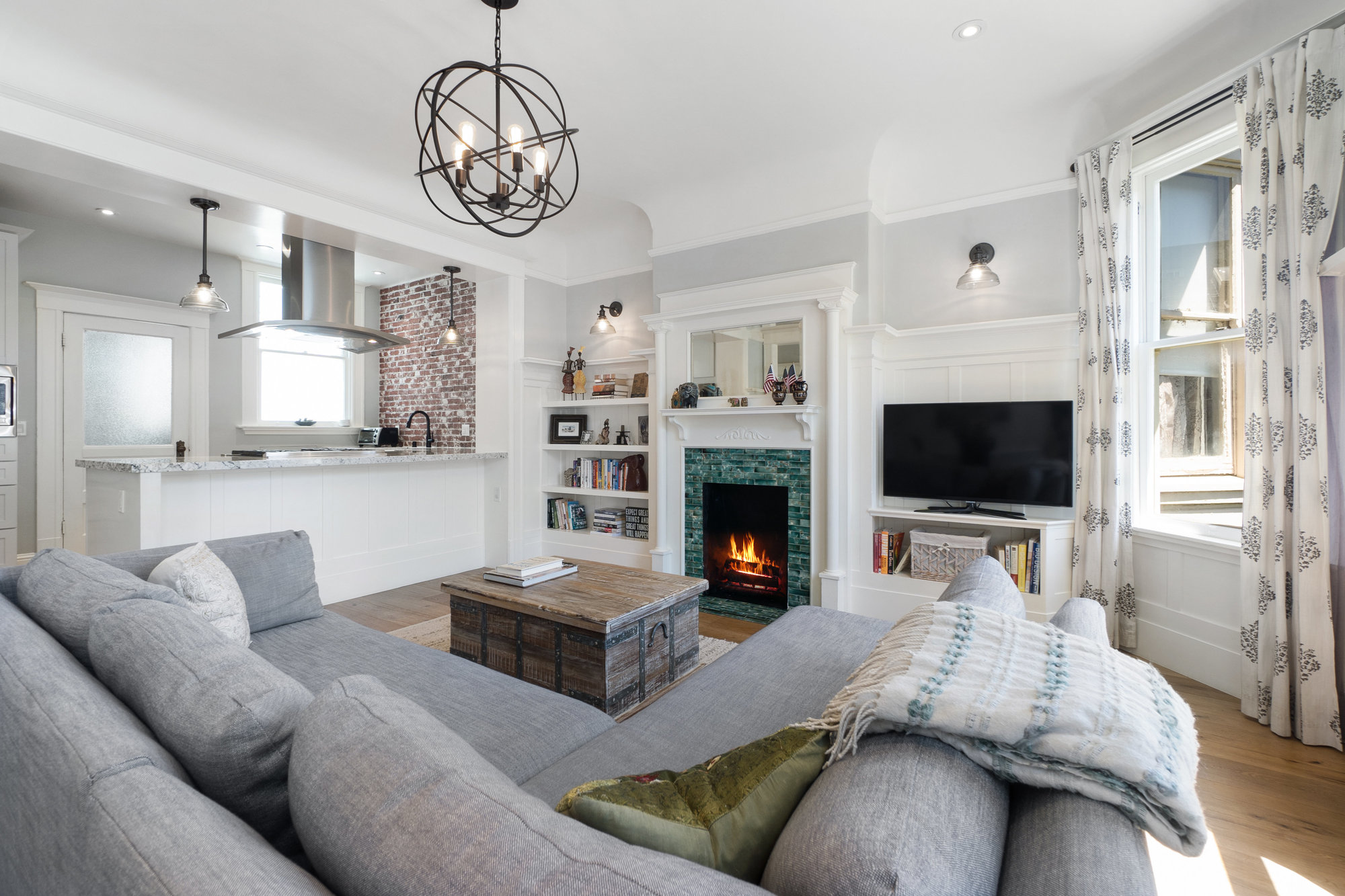 Property Photo: Living room, featuring a fireplace with large white mantle and built-in book shelves