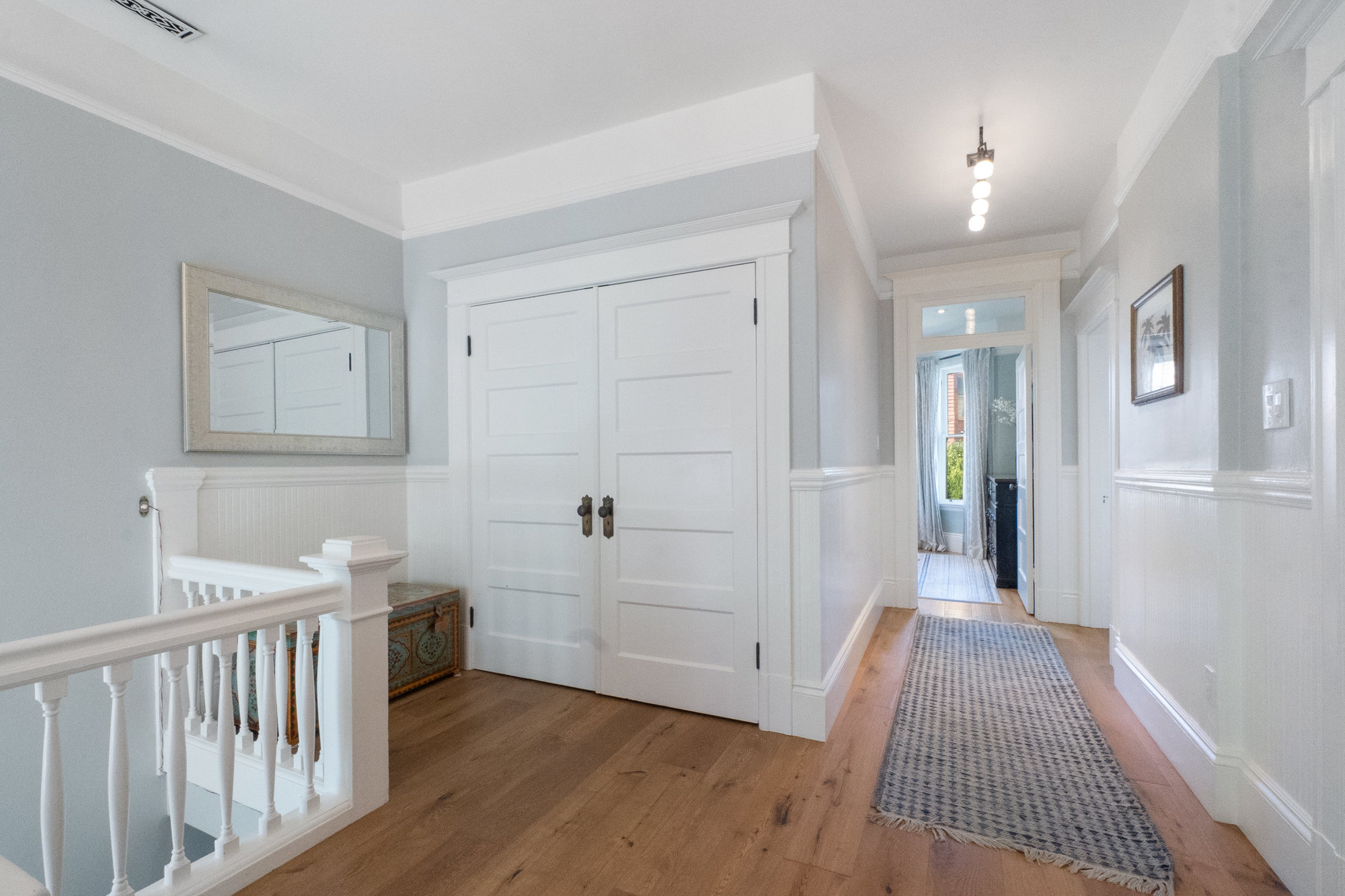 Property Photo: View of a large double closet in the hall and wainscoting throughout 
