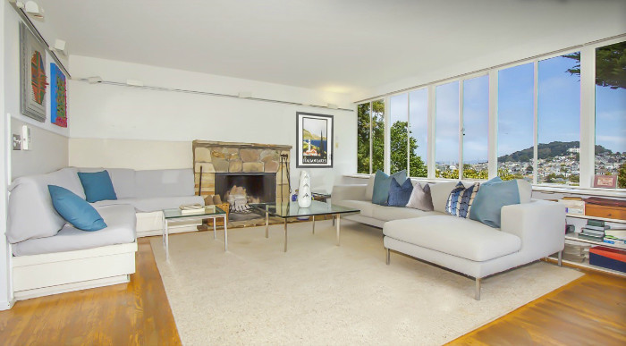 Property Photo: View of the living room, featuring a wall of windows and a fireplace