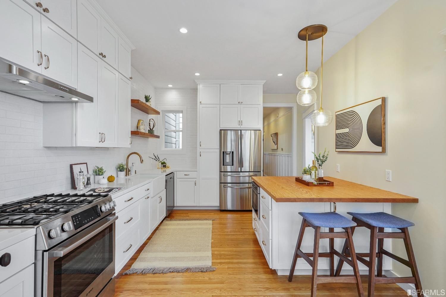 Property Photo: Kitchen featuring white cabinetry, lux stove, and modern lighting