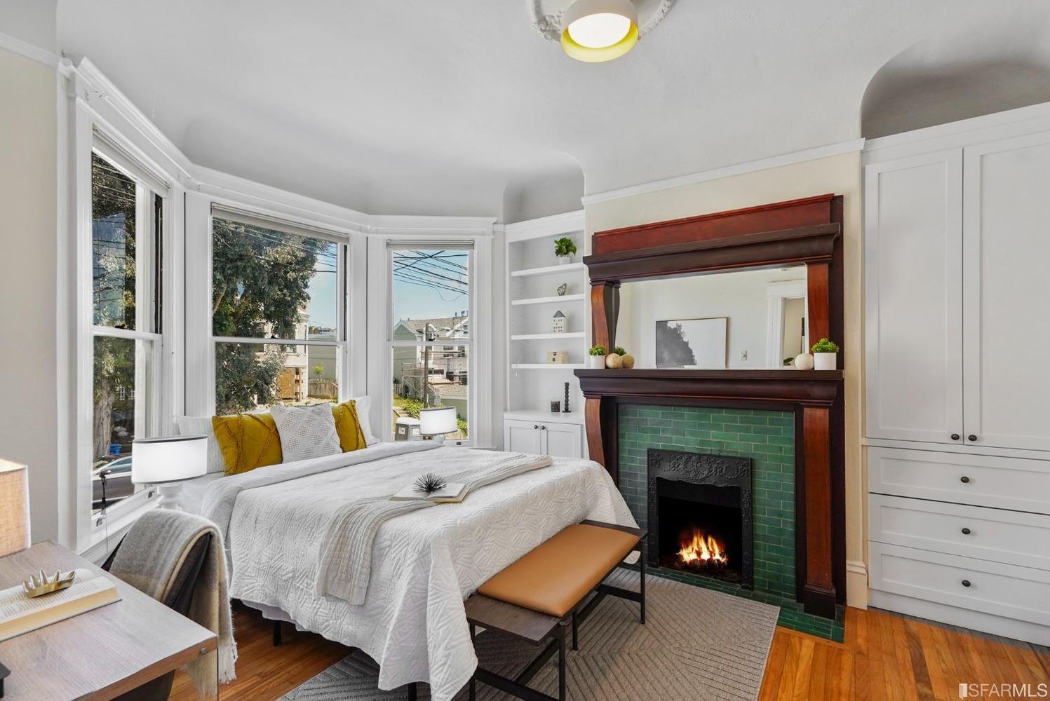 Property Photo: View of the primary bedroom, featuring a large fireplace and bay window