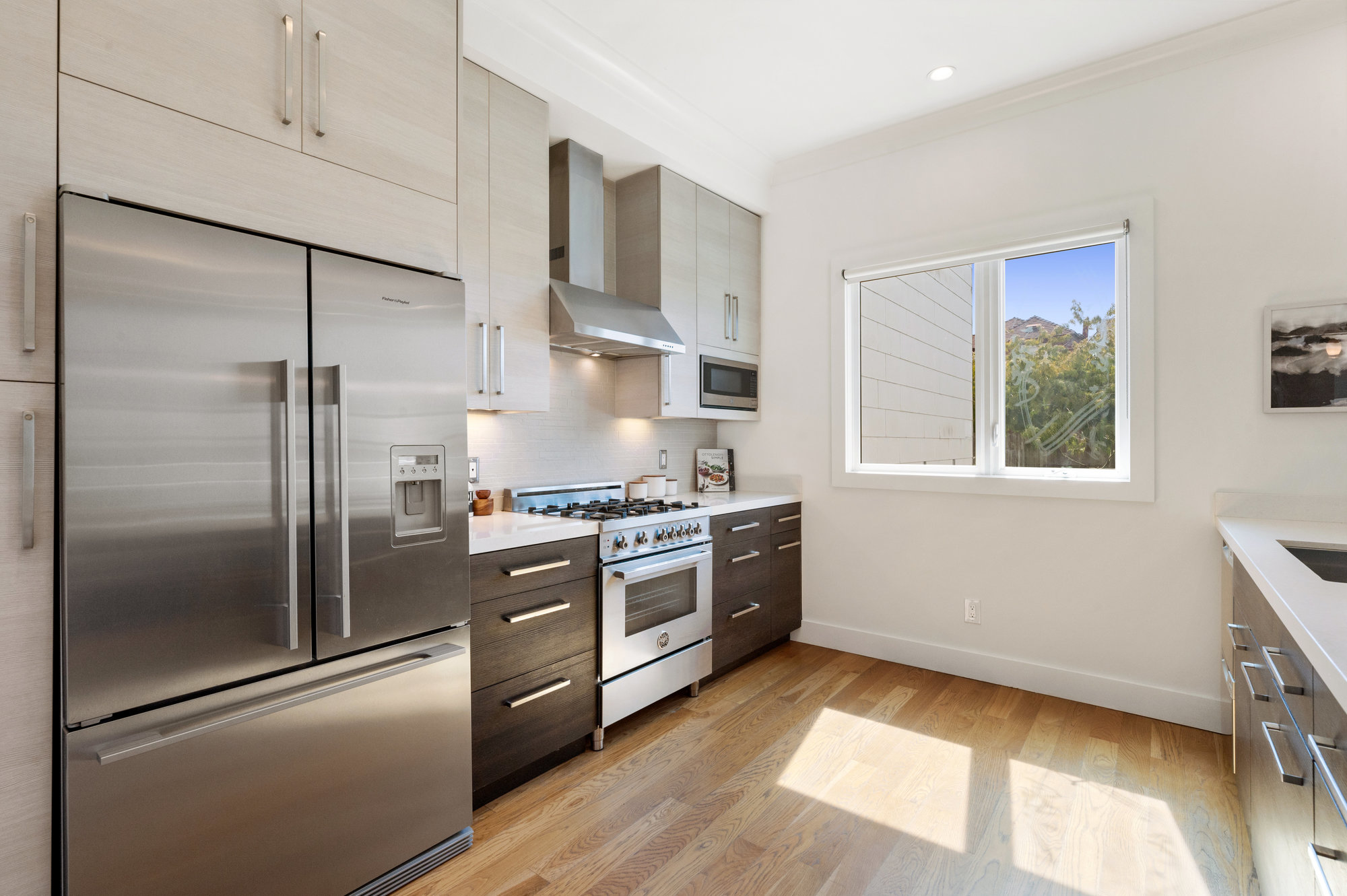 Property Photo: View of the kitchen, showing a large stainless refrigerator and window