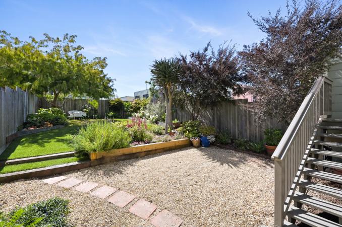Property Thumbnail: View of the large rear yard at 719 18th Avenue, showing various plants and trees