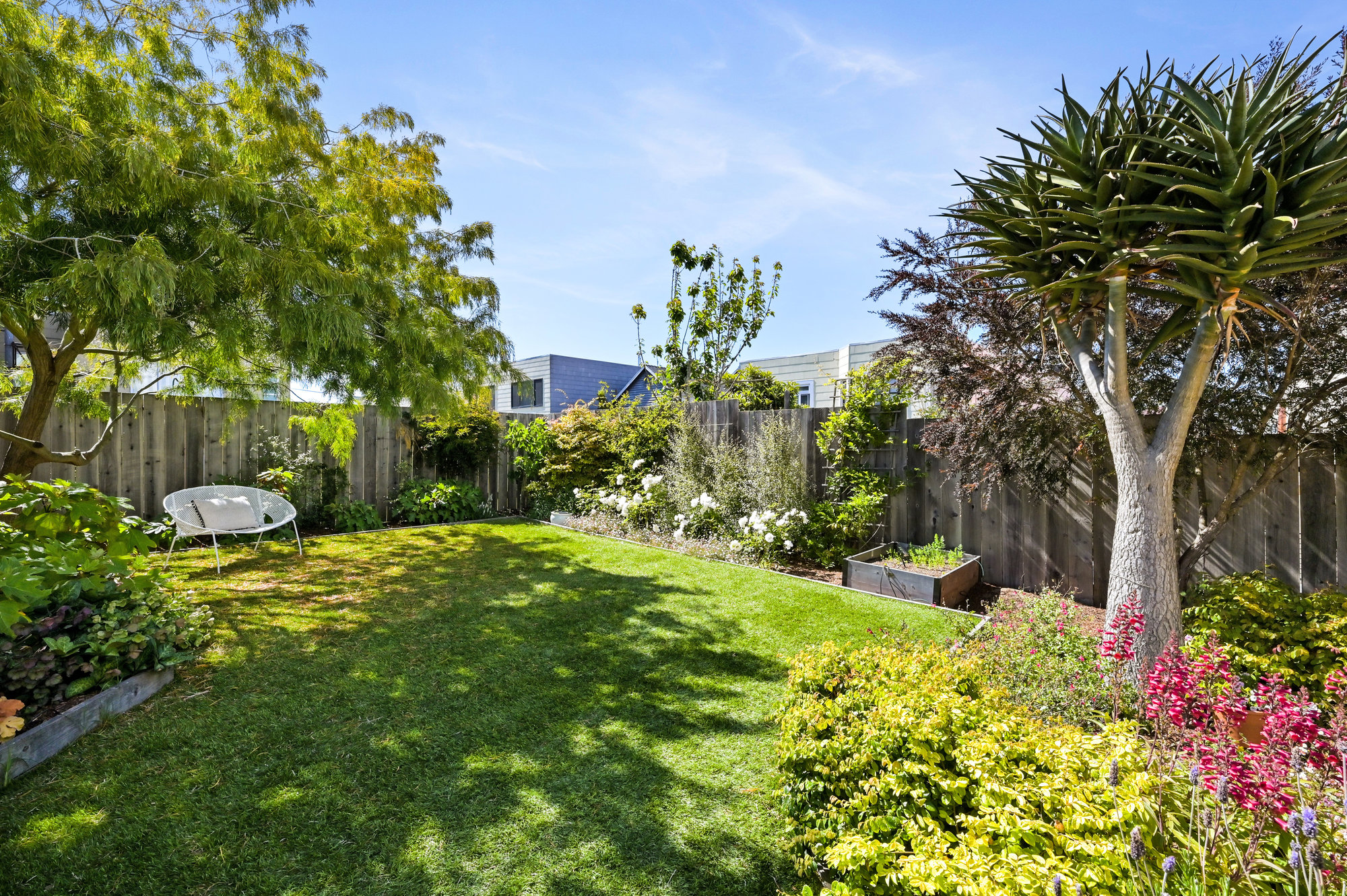 Property Photo: View of the raised flower and vegetable beds surrounded by trees