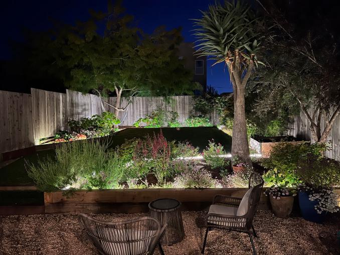 Property Thumbnail: View of the rear yard at night, lit-up by landscape lights