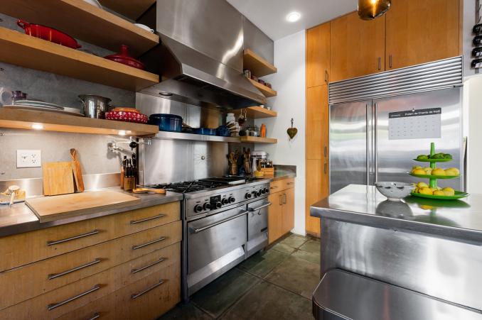 Property Thumbnail: View of the cooking area, showing a large stainless steel range and oversized fridge and island 