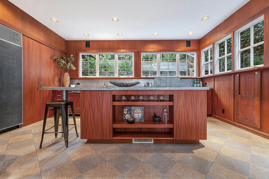 Property Photo: View of the kitchen, featuring wood paneling and wrap-around windows on two walls