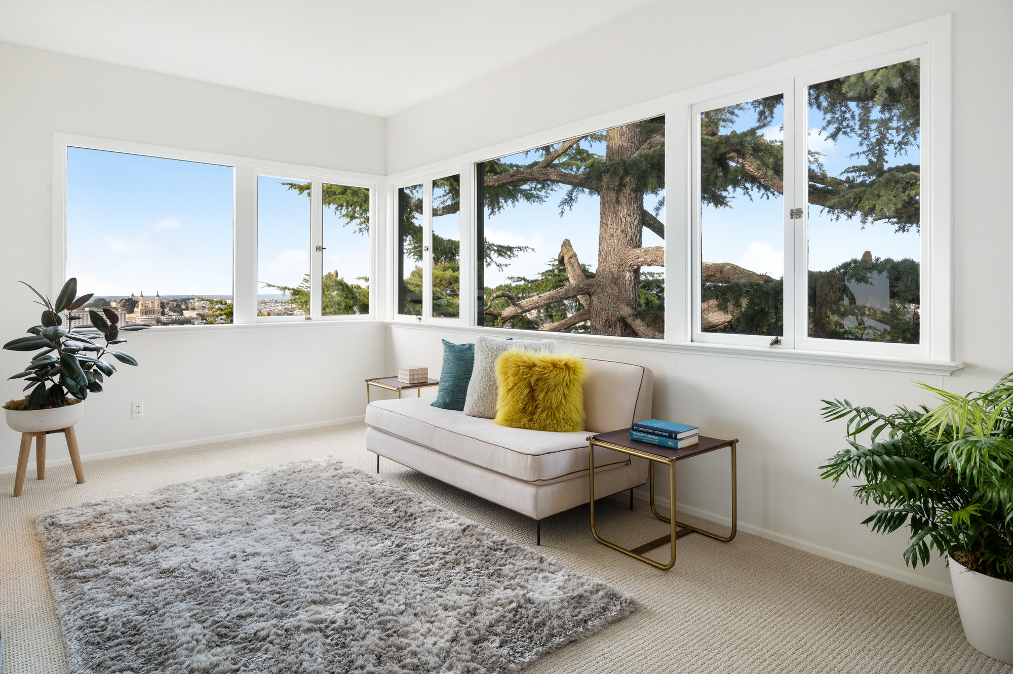 Property Photo: View of the primary sitting area with views of trees and the city beyond