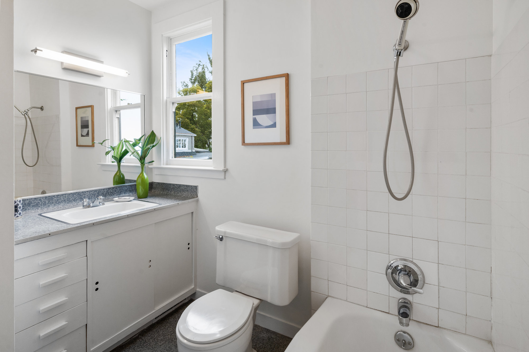 Property Photo: Bathroom with bath tub, a window, and vanity