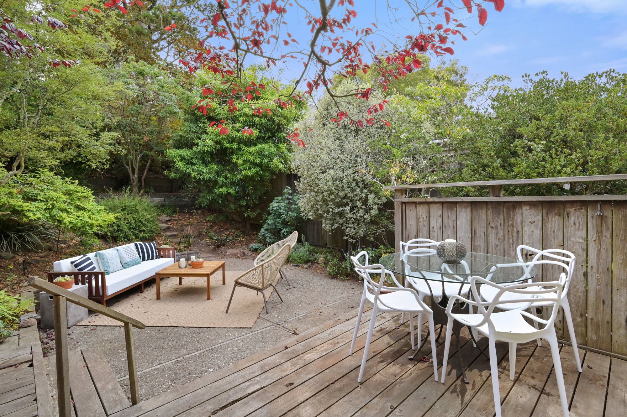 Property Photo: View of the outdoor dining area on the wooden deck with the garden beyond
