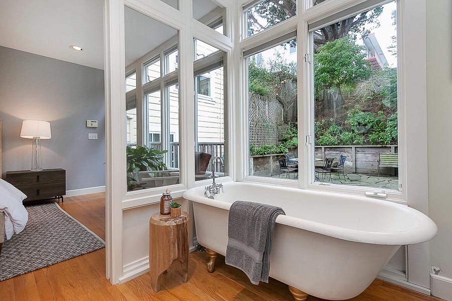 Property Photo: View of the en-suite, featuring a free-standing bathtub positing by large windows