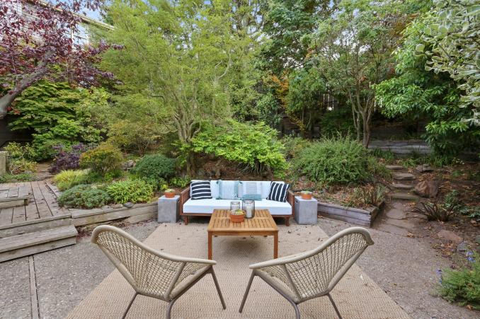 Property Thumbnail: Outdoor living area with steps leading through the lush, mature garden