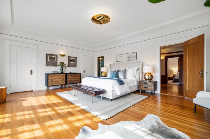 Property Thumbnail: Primary bedroom with light shining across wood floors
