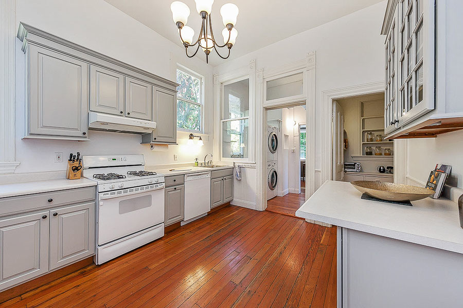 Property Photo: View of the kitchen, showing light grey cabinets and wood floor