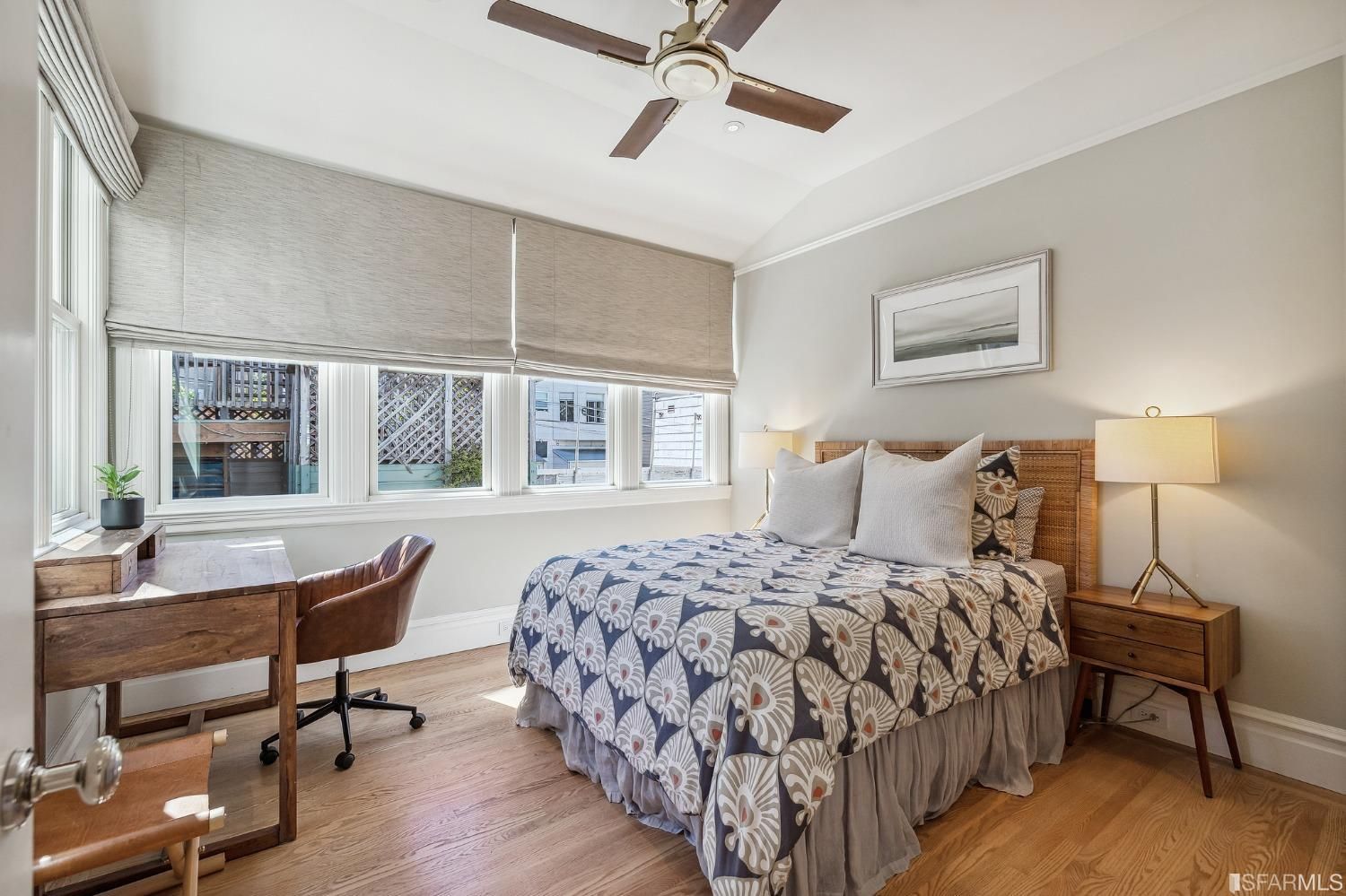 Property Photo: Bedroom one with wood floors and several large windows