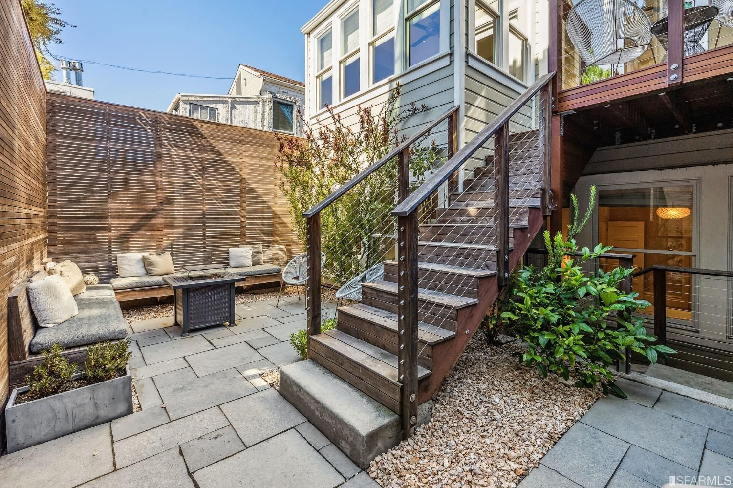 Property Photo: Lower patio with outdoor living space and steps leading to the upper deck