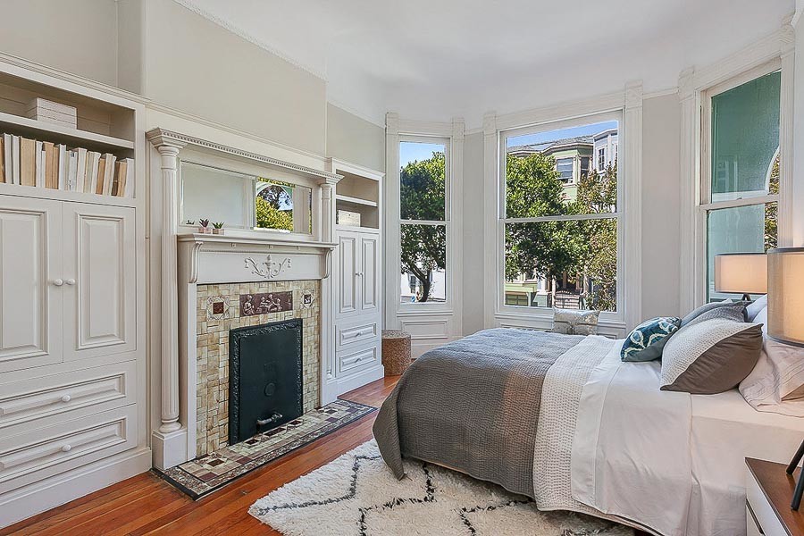 Property Photo: View of a bedroom with a fireplace and wood floors