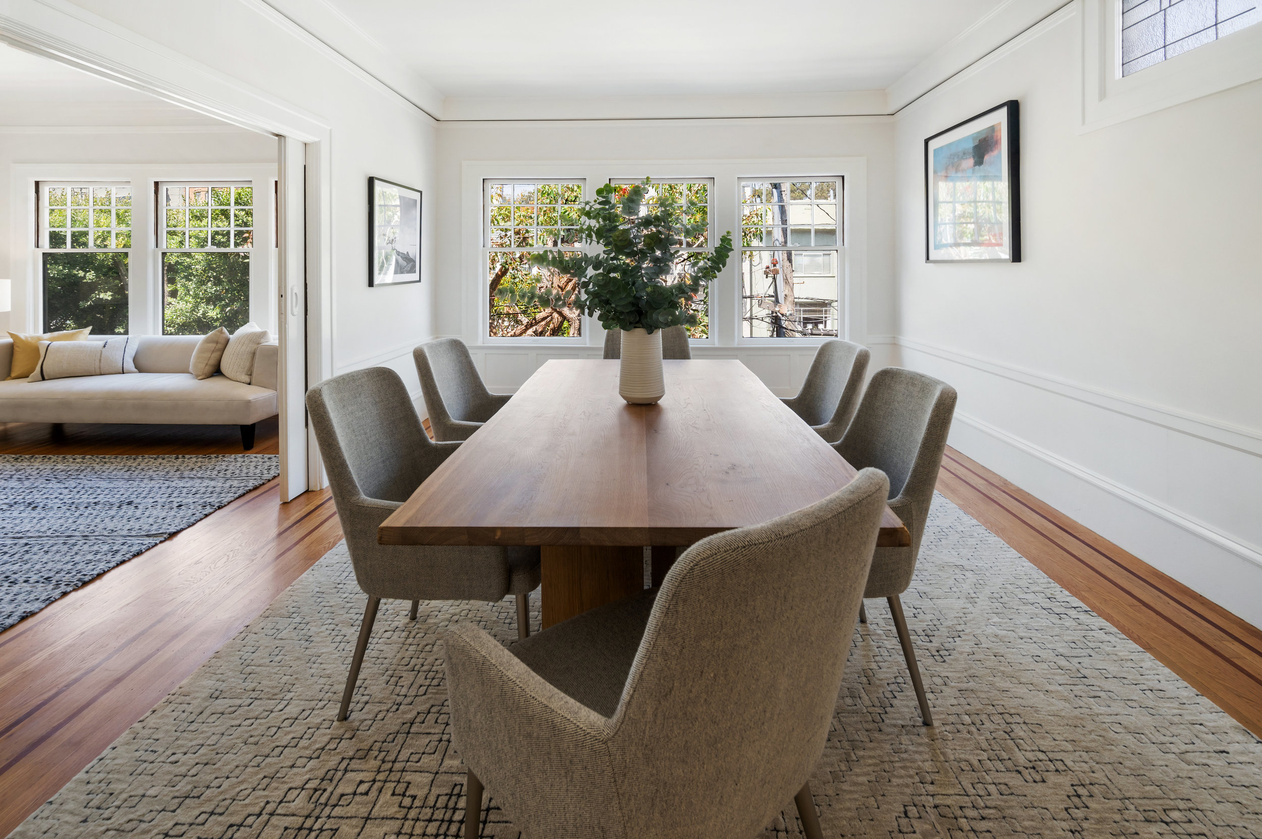 Property Photo: Dining room, featuring three large windows at one end