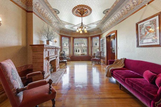 Property Thumbnail: Long view of a formal living room, featuring a fireplace and ornate crown moulding 