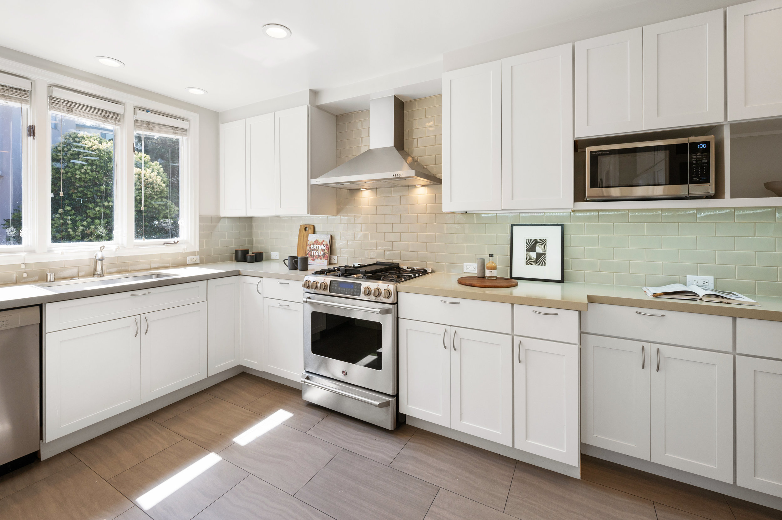 Property Photo: Kitchen, showing abundant natural light and white cabinets