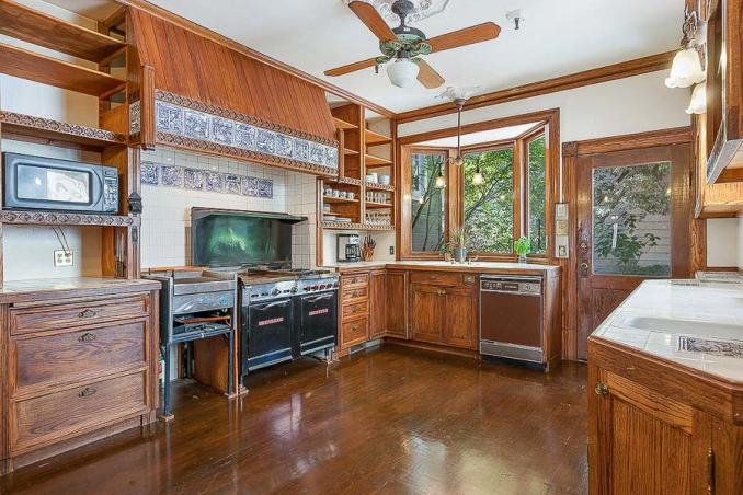 Property Thumbnail: View of the kitchen, featuring wood cabinets, wood floors, a large window and high-end appliances