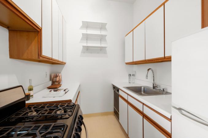 Property Thumbnail: Lower level suite, showing the kitchen with cabinets, sink, fridge, and stove