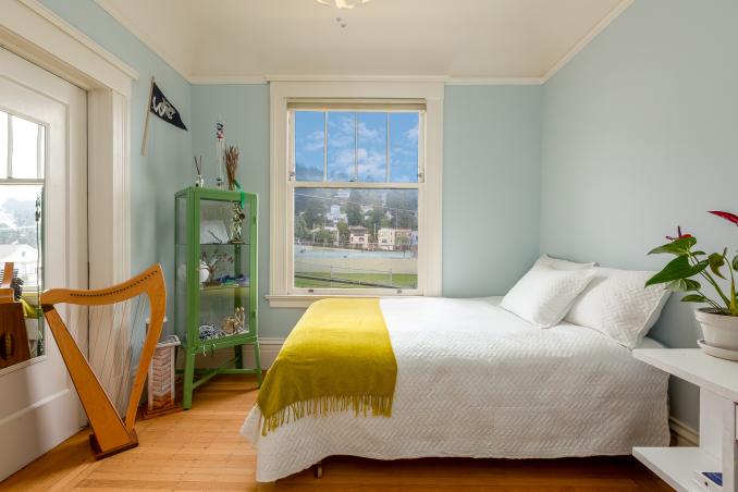 Property Thumbnail: Bedroom one, showing wood floors and a large window