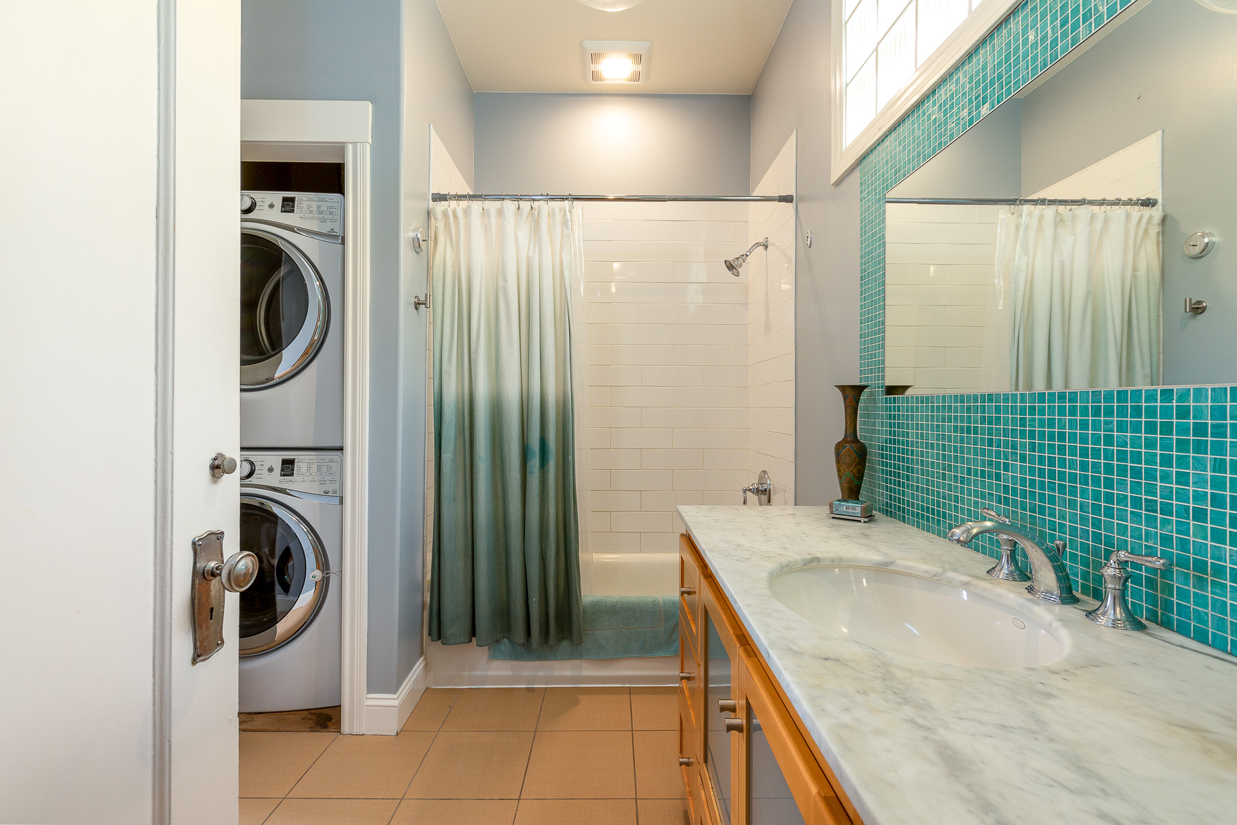 Property Photo: Bathroom with blue tile backsplash and a large shower