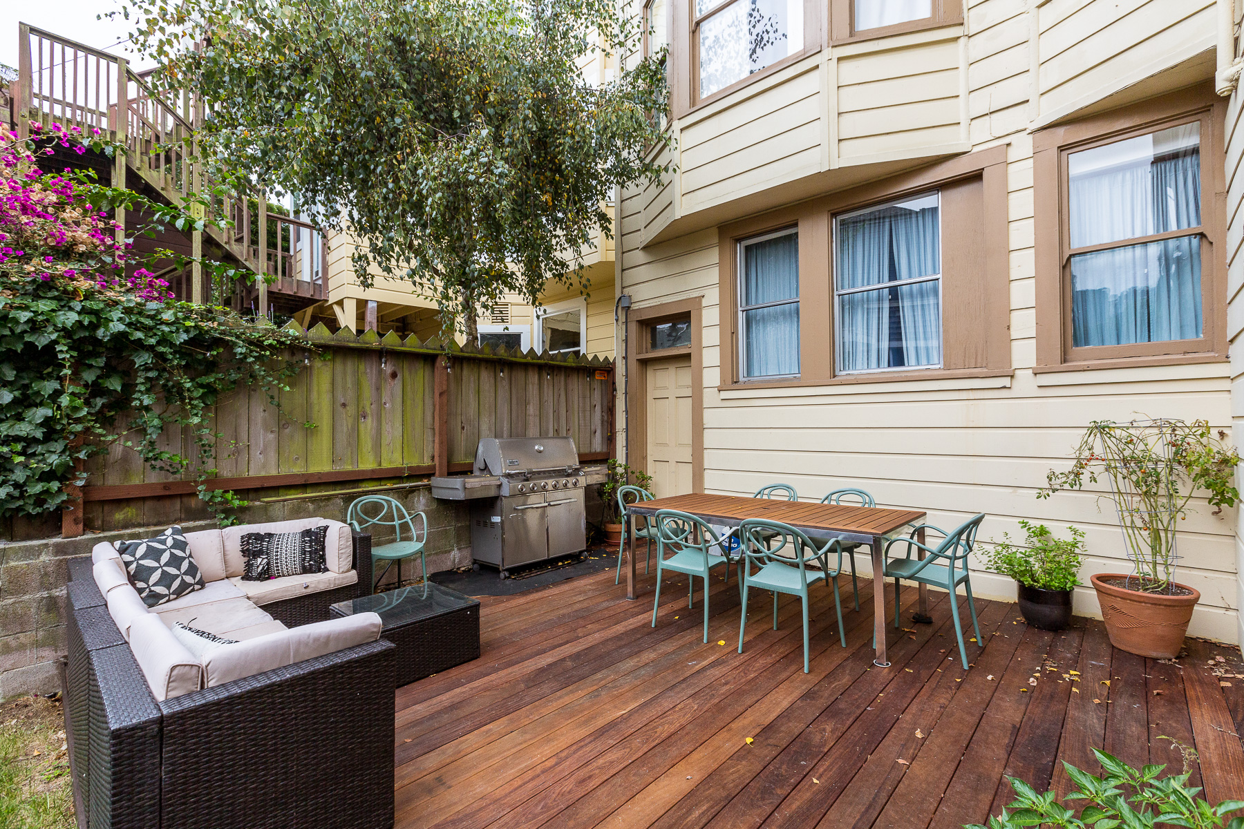 Property Photo: Rear yard with a wood deck and outdoor dining space
