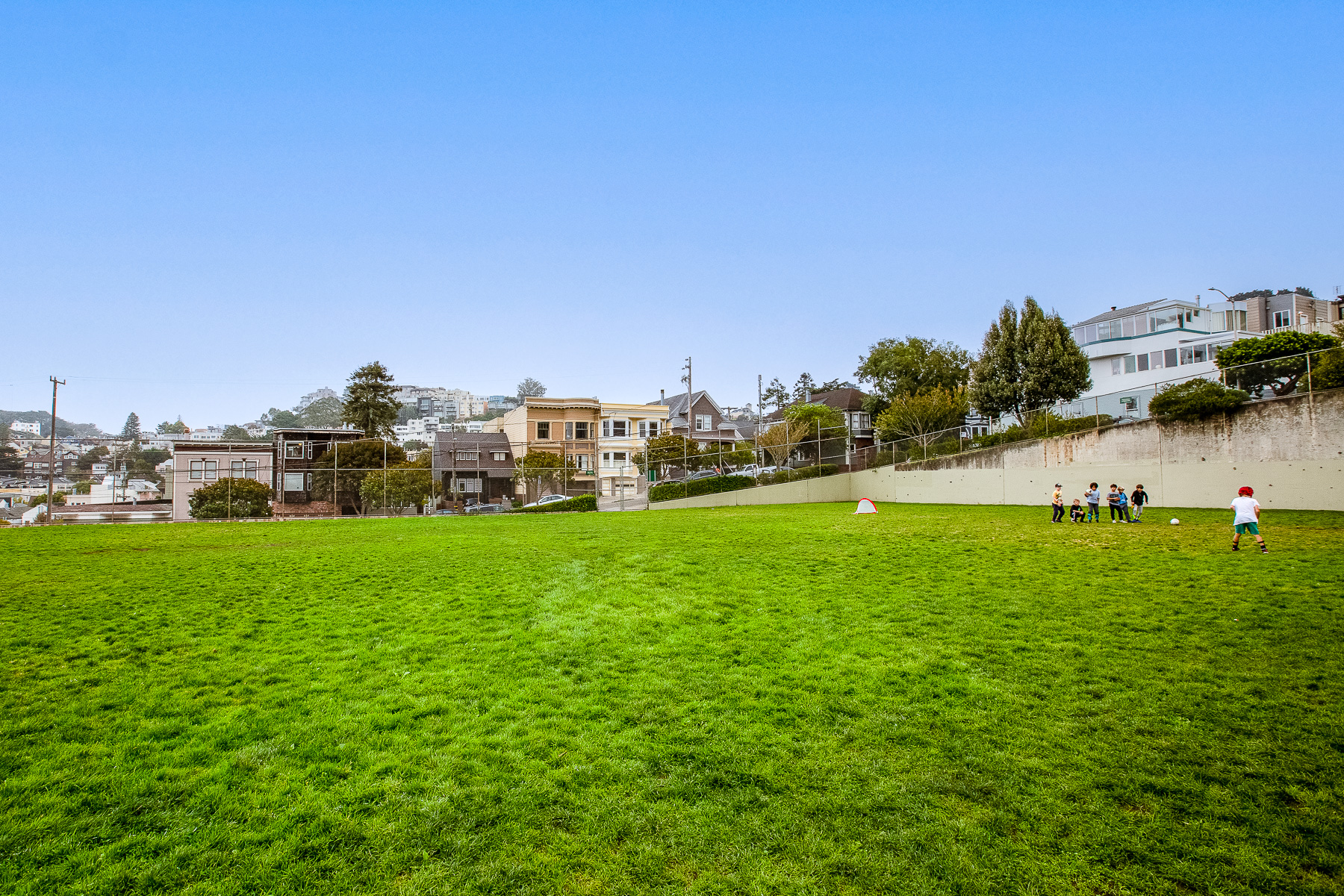 Property Photo: A large green field with children playing at nearby Grattan Park