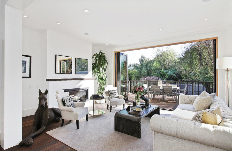 Property Photo: View of a large living room with large open doors leading to an out-door living area