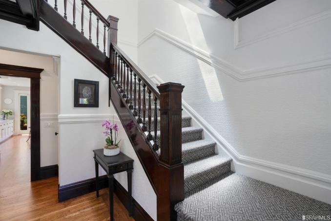 Property Thumbnail: A large staircase with elegantly crafted railing lead to the second story of the home
