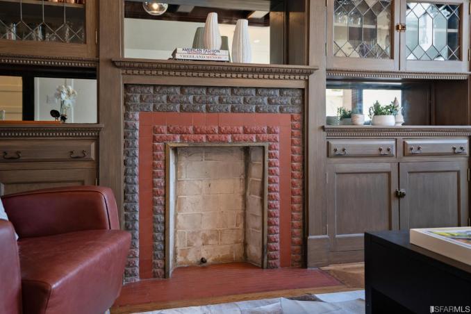 Property Thumbnail: Close-up of the fireplace, showing brick surround and built-in cabinetry 