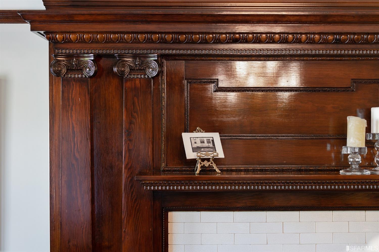 Property Photo: Close-up view of the ornate woodwork and craftsmanship of the fireplace mantle
