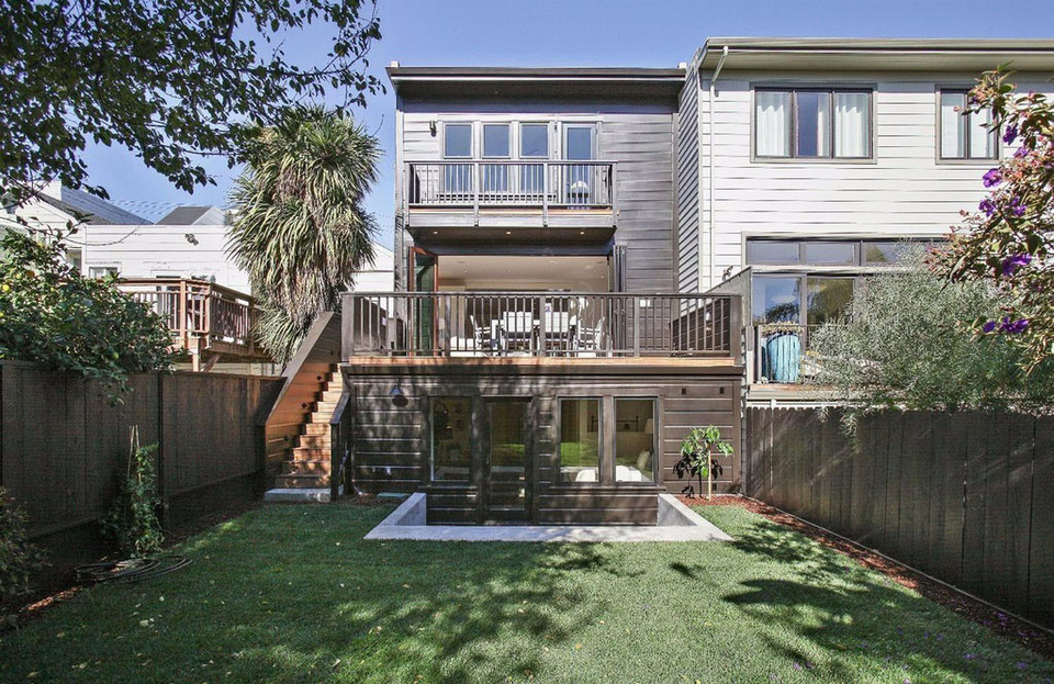 Property Photo: Rear exterior view of 4069 25th Street, showing a large lawn and multiple decks