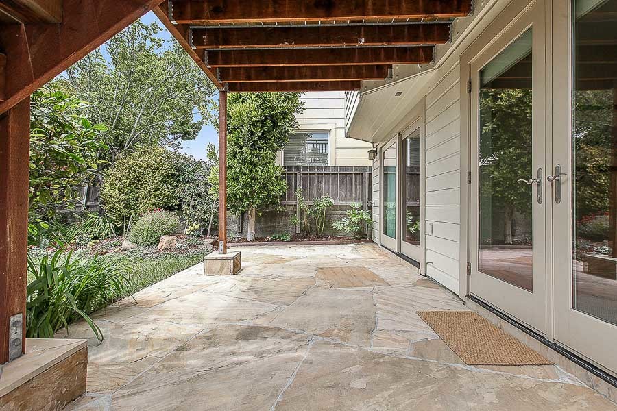 Property Photo: View of a large stone patio and two sets of doors leading inside 