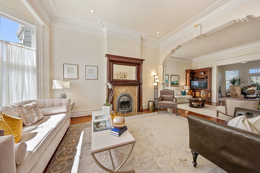 Property Photo: View of the living room, featuring a fireplace and an ornate archway 