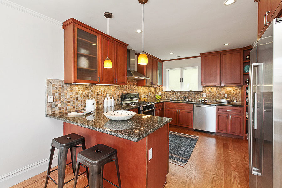 Property Photo: View of the kitchen, featuring wood cabinets and floors