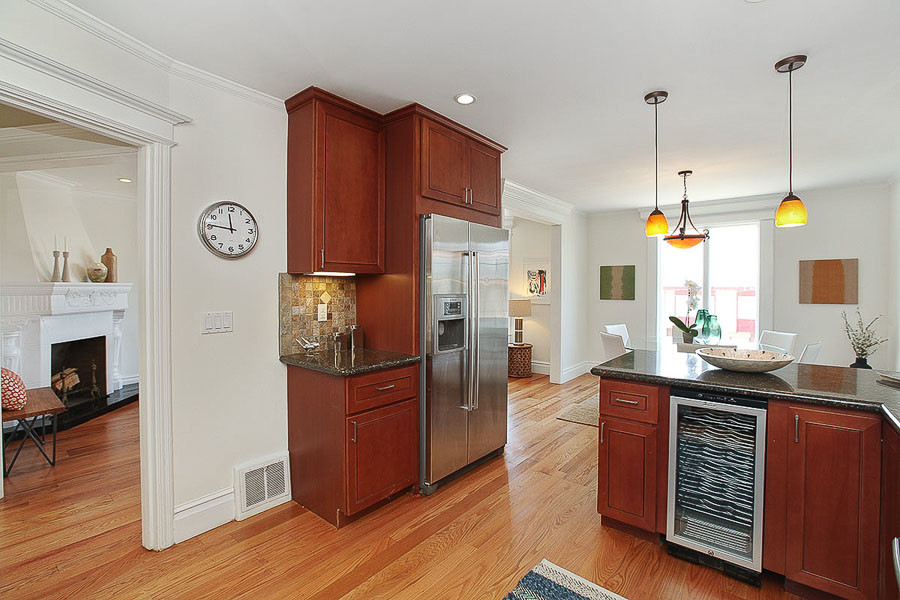 Property Photo: View of the kitchen, showing the fridge and a partial view of the living room