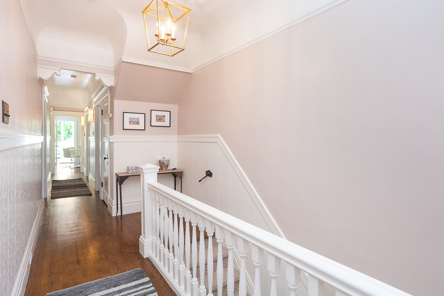 Property Photo: View of the hallway, showing wood floors and white wainscoting