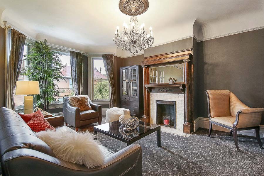 Property Photo: View of the living room, featuring a large fireplace and mantel 