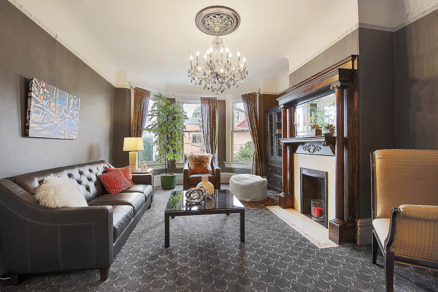 Property Photo: Living room with large windows and a chandelier 