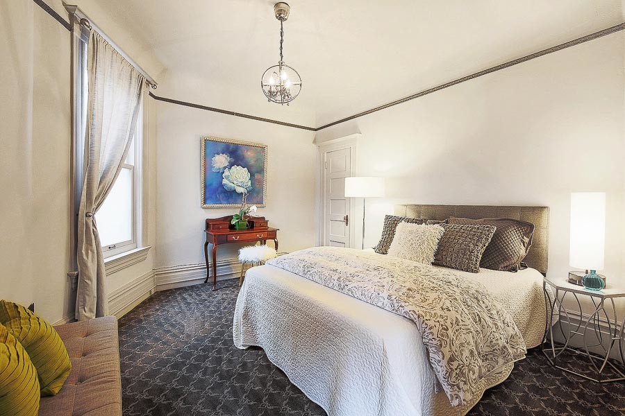 Property Photo: View of a large bedroom a window and carpeting 