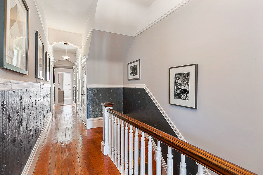 Property Photo: View of the hallway showing wood floors and vintage wainscoting