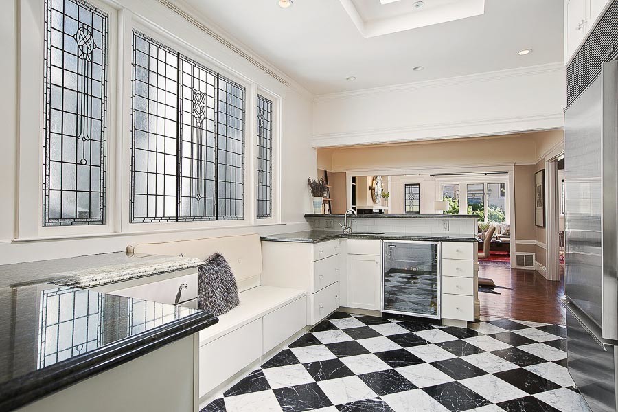 Property Photo: View of the kitchen, featuring black and white tiled floor and large stained glass windows
